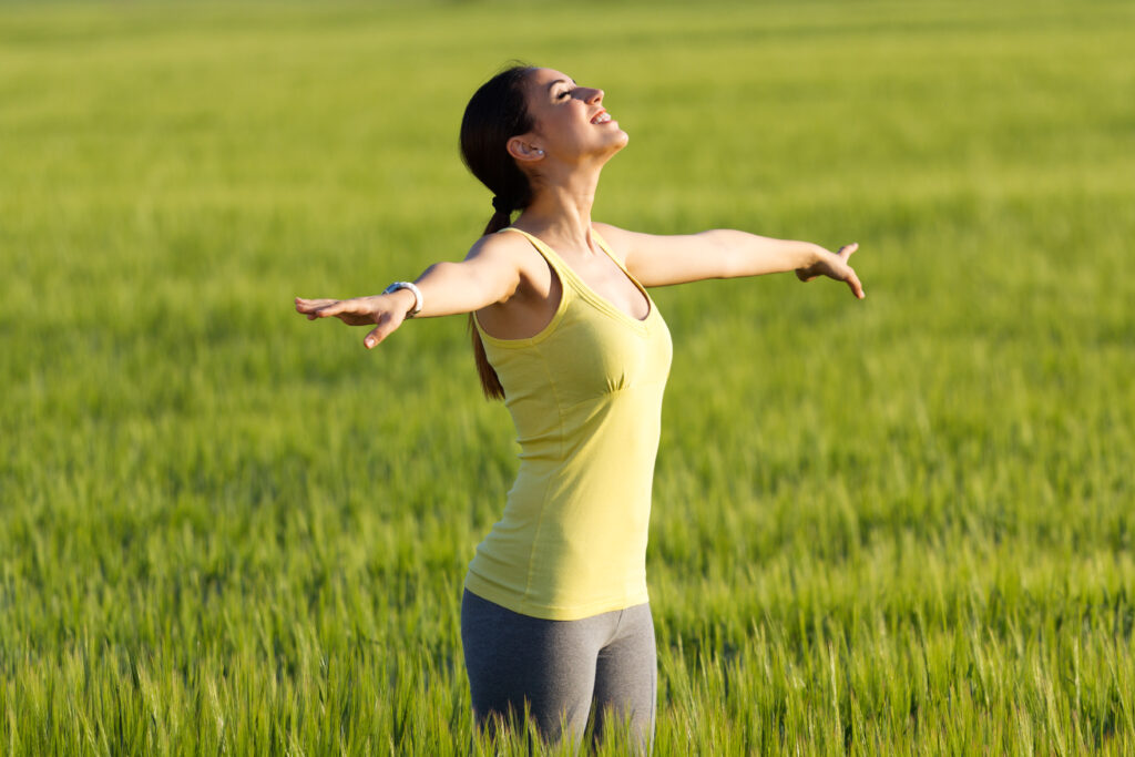 Beautiful young woman enjoying the spring standing in a cereal f